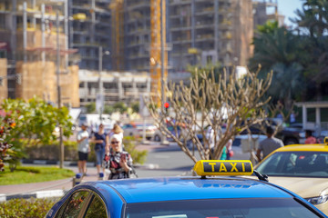 Obraz premium A cab at high speed on a motorway in an urban area with the lit taxi sign on top of its roof.