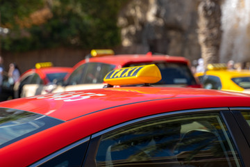 Fototapeta na wymiar Taxi cars are waiting in row on the street - selective focus.