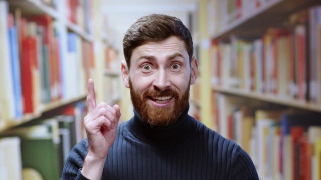Portrait ambitious caucasian young man coming uo with idea smiling successful and confident learning information at modern institure library.
