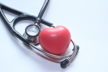 Stethoscope and heart on white background, top view