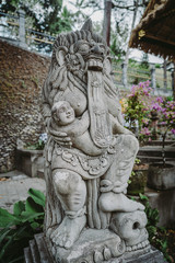 A close up on a guardian figure next to Pura Tirta Empul temple on Bali. Traditional and historical site. Sculpture of a Balinese temple guardian