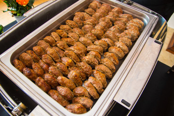 Fried meatballs with herbs in a hot catering baking food tray
