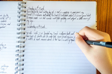 A young boy writes a diary of events during coronavirus lockdown as handwriting practice and to...