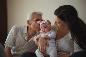 Grandfather kissing his little cute granddaughter