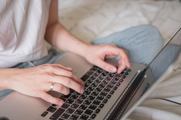 Fototapeta premium Woman's hands working on laptop at home. Distance work, distance education, home office close up. Selective focus