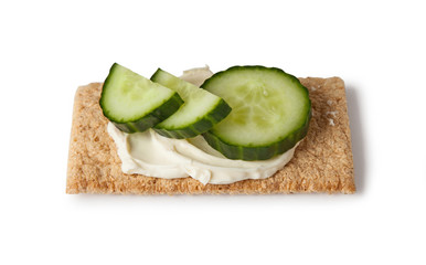 crispbread with cream cheese and cucumber slices, isolated on white background