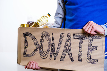 Homeless poor man holding carton board with word food DONATE