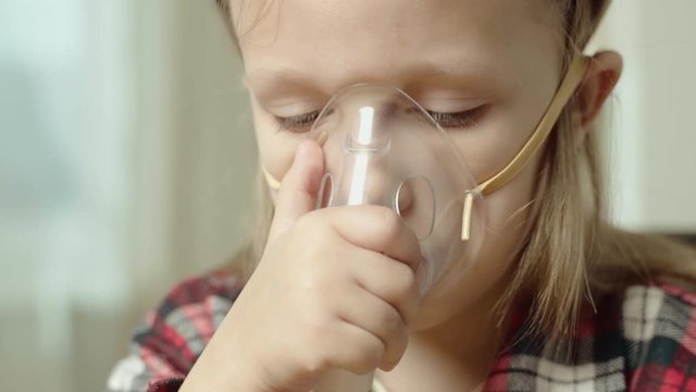 Little Girl Child Makes Inhalation In Face Mask With Nebulizer.