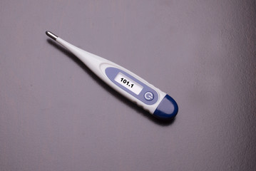 Thermometer indicates high tempature as a result from an infection from corona or flu virus