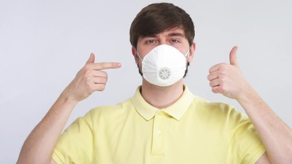 safety sterile respiratory mask on male face while covid-19 with thumbs up gesture