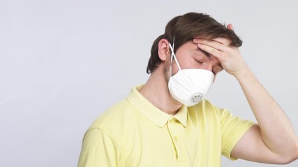man in good respiratory mask touching his forehead to check body temperature