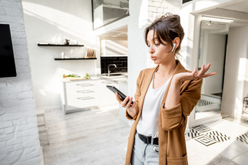 Well-dressed woman having some business work on a smart phone while working from home