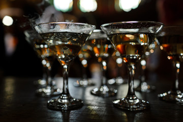 Martini glasses stand on a wooden stand. Martini glasses are on the bar. clean glasses with alcohol. selective focus