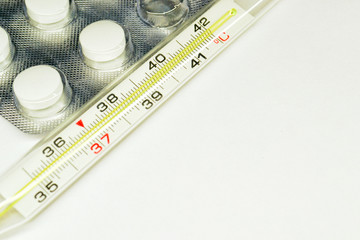 thermometer and pills isolated on white background