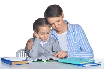 Portrait of mother with daughter doing homework
