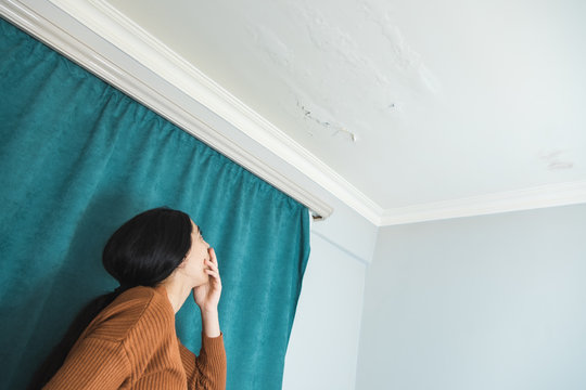 damaged ceiling with sad woman
