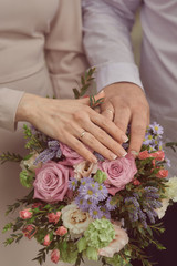 Obraz na płótnie Canvas bride and groom hold hands on a bouquet