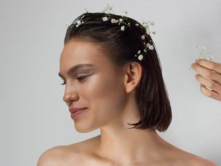 Close up portrait of a face with beautiful skin and nude makeup, eyeliner and long eyelashes, puffy...