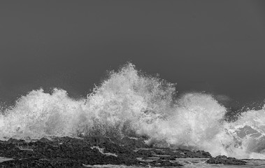Big Ocean waves crashing into rocks and exploding.