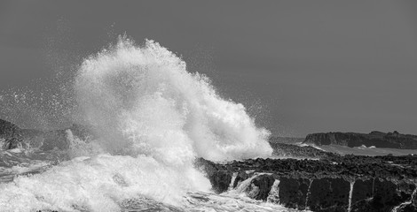 Big Ocean waves crashing into rocks and exploding.