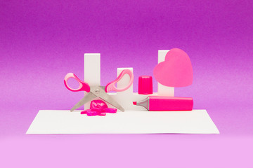 Scissors, marker and other decorations on a purple and shiny white background