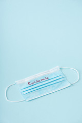 medical mask with epidemic lettering on blue with copy space