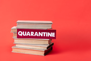 books and card with quarantine lettering on red with copy space