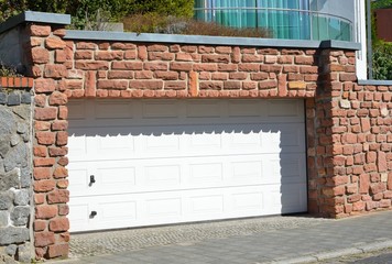 Moderne Beton-Garage mit Automatik-Tor in der Hauszufahrt