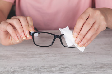 Hand woman cleaning her glasses with cloth