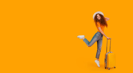 happy girl in a hat and a suitcase in a jump on an isolated yellow background. Vacation. Copy Space.