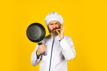 Professional kitchenware. Frying meal. Healthy food. Bearded chef preparing breakfast. Nonstick pan for frying. Enameled cooking vessels. Man hold pan. Nonstick cookware. Frying without oil