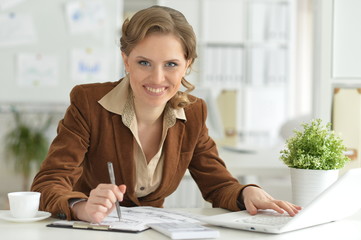 Portrait of cute young businesswoman at her working place