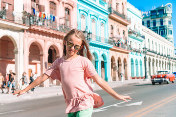 Naklejka premium Tourist girl in popular area in Havana, Cuba. Young kid traveler smiling