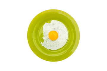 Fried egg in a green plate isolated on white background. Light morning breakfast. Top view, flat lay.