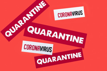 top view of quarantine and coronavirus lettering isolated on red