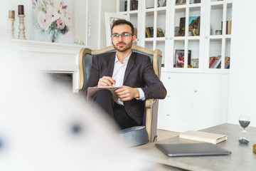 Fototapeta premium Dark-haired modern entrepreneur relaxing in an armchair