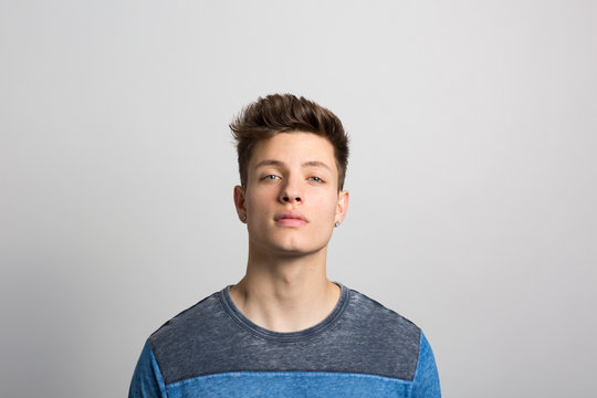 Portrait of young man standing against white background