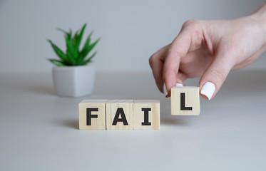 a young caucasian woman at his office desk with a rubber stamp with the word fail