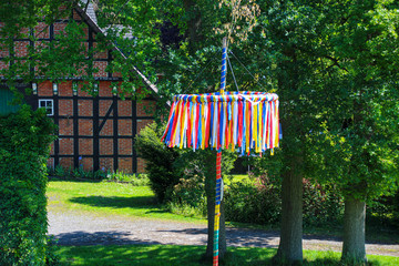 traditional maypole with half-timbered house in may - obrazy, fototapety, plakaty