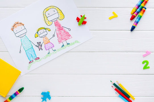 Kids drawing of family in medical face masks on white wooden background