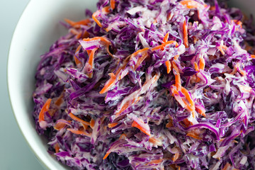 Close up of red cabbage and carrot salad, healthy coleslaw in white bowl