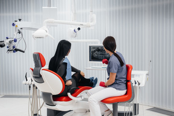 The dentist shows a picture of the patient's teeth and tells the necessary treatment. Dentistry,...