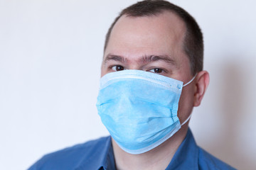 Male doctor with protective medical mask after the shift, panic, fatigue, pandemic corona virus.