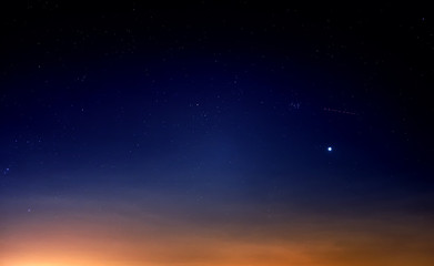 blue starry sky landscape at dusk against red sunset clouds background wide view of universe with...
