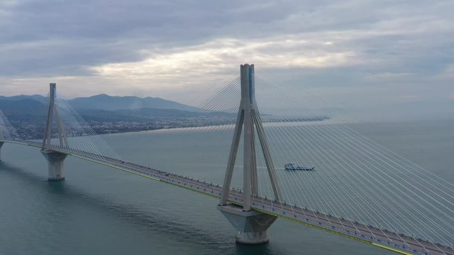 Aerial view of long cable-stayed Rio bridge in Greece at clouds weather, Ferry station