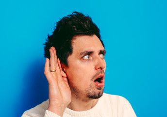 Overhears a man, tries to listen.