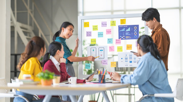 Young Asian woman leading business creative team in mobile application software design project. Brainstorm meeting, work together, internet technology, girl power, office coworker teamwork concept - Powered by Adobe