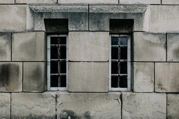old brick wall with large stone blocks and 2 elongated windows