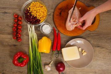 Ingredients for Burritos, chicken meat, corn, tomatoes and peppers on wooden background. Top view