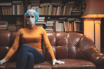 Woman with protective antiviral mask sitting at home in isolation / quarantine.